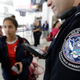 A U.S. Customs and Border Protection officer helps a passenger navigate facial recognition kiosks at a United Airlines gate before boarding a flight to Tokyo, at George Bush Intercontinental Airport, in Houston.